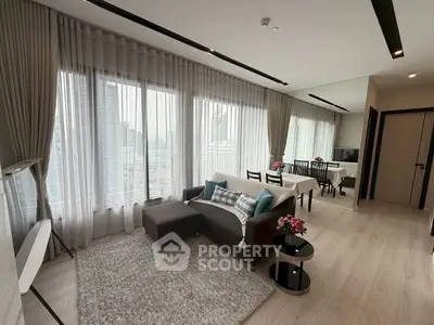 Spacious modern living room with large windows and elegant decor in a high-rise apartment.