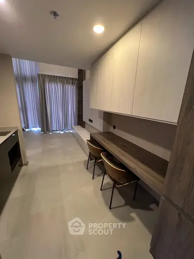 Modern study area with built-in desk and chairs in a stylish apartment