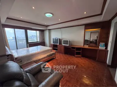 Spacious bedroom with city view, featuring parquet flooring and classic wooden furniture.