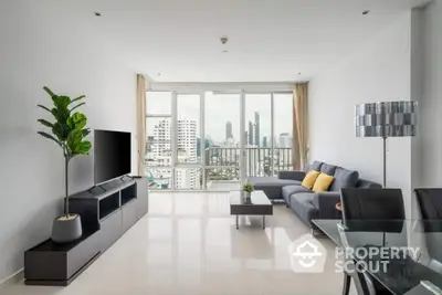 Modern living room with city view, sleek furniture, and abundant natural light.