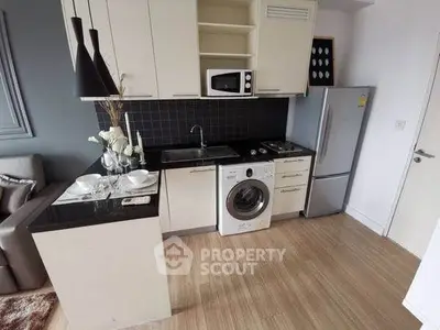 Modern compact kitchen with washing machine and sleek appliances in stylish apartment.