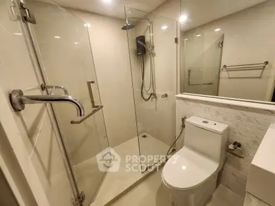 Modern bathroom with glass shower and sleek fixtures in a contemporary apartment.