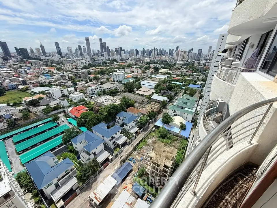 Stunning cityscape view from a high-rise balcony overlooking urban skyline and residential area.
