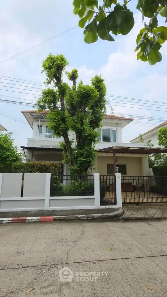Charming two-story house with lush greenery and modern design in a serene neighborhood.