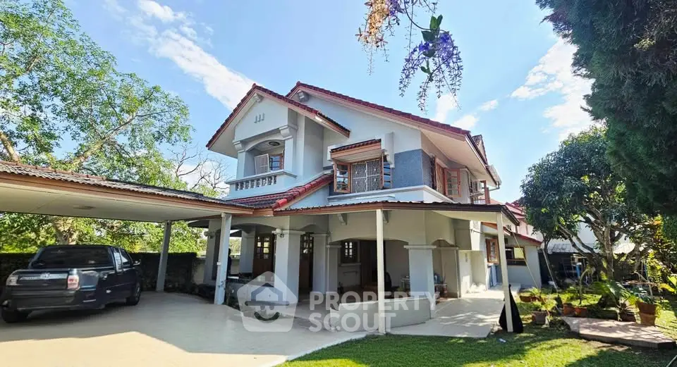 Charming two-story house with carport and lush garden, featuring traditional architecture and spacious outdoor area.