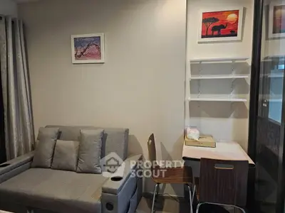 Cozy living room with modern sofa and stylish wall art, perfect for relaxation and work-from-home setup.