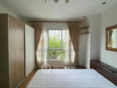 Bright bedroom with large window and modern furnishings, offering a serene view of greenery outside.
