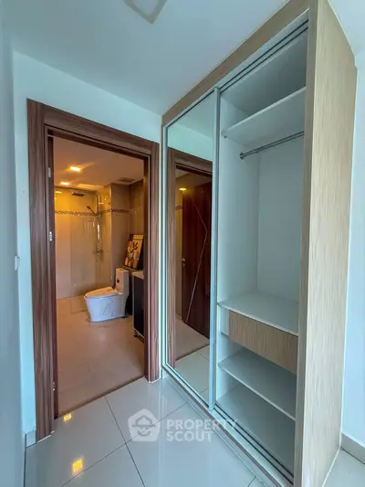 Modern bathroom with sleek closet and glass shower enclosure