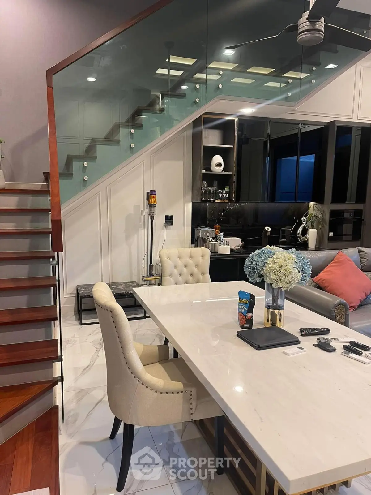 Luxurious modern living room with elegant staircase and stylish dining area