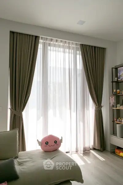 Cozy living room with large window, elegant curtains, and plush decor