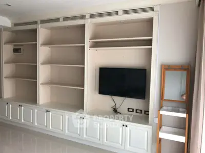 Spacious living room with built-in shelves and modern TV setup