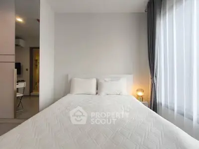 Cozy bedroom with natural light and modern decor in a stylish apartment.