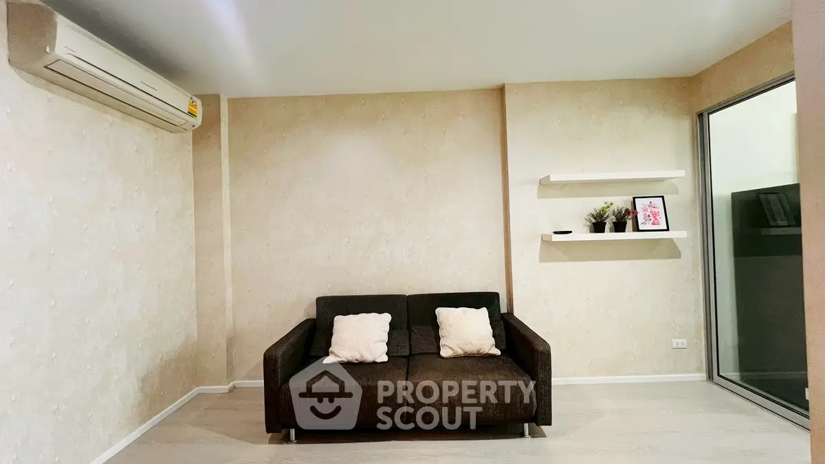 Cozy living room with modern sofa and wall-mounted shelves in a stylish apartment.