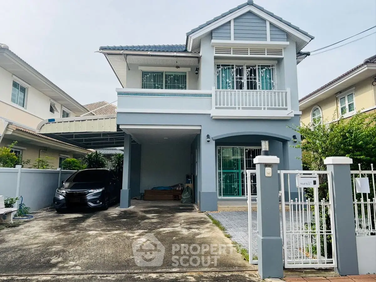 Charming two-story house with driveway and gated entrance in a suburban neighborhood.