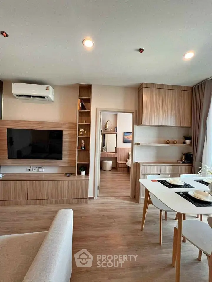 Modern open-plan living room with stylish wooden cabinetry and dining area