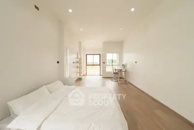 Spacious minimalist bedroom with large windows and natural light