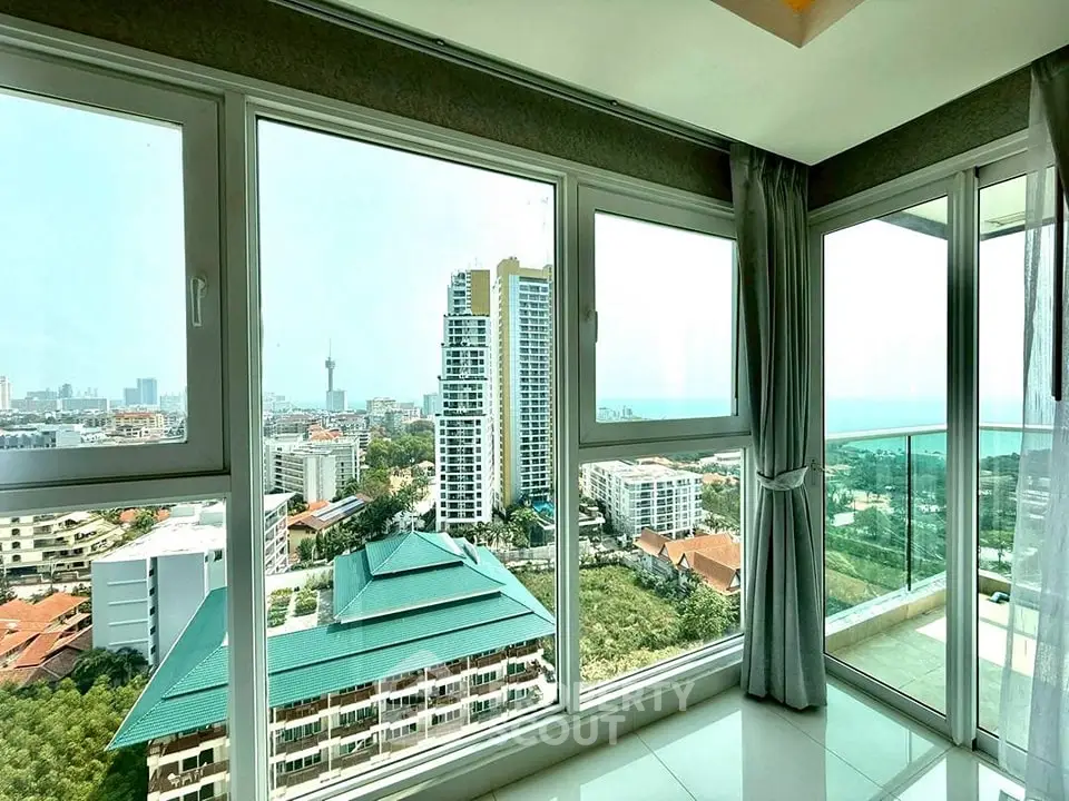 Stunning high-rise apartment with panoramic city and ocean views from large windows.