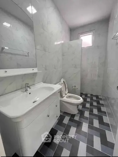 Modern bathroom with sleek white fixtures and stylish tile flooring
