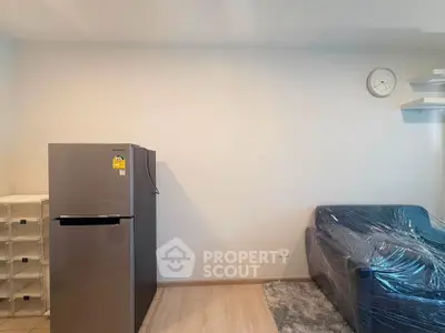 Modern living room with fridge and sofa, minimalistic design.