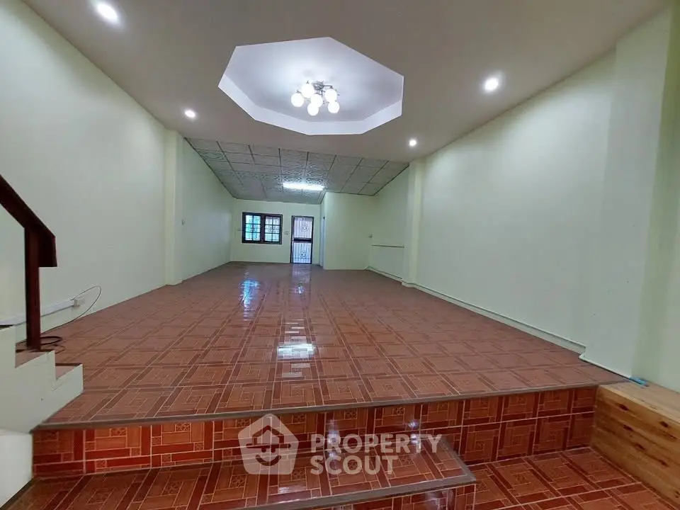 Spacious open-plan living area with unique ceiling design and tiled flooring