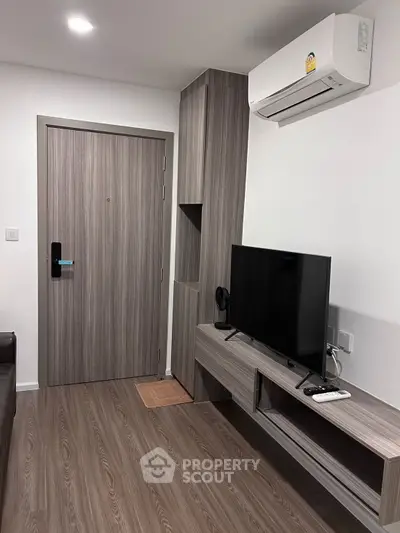 Modern living room with sleek wood flooring and built-in TV unit
