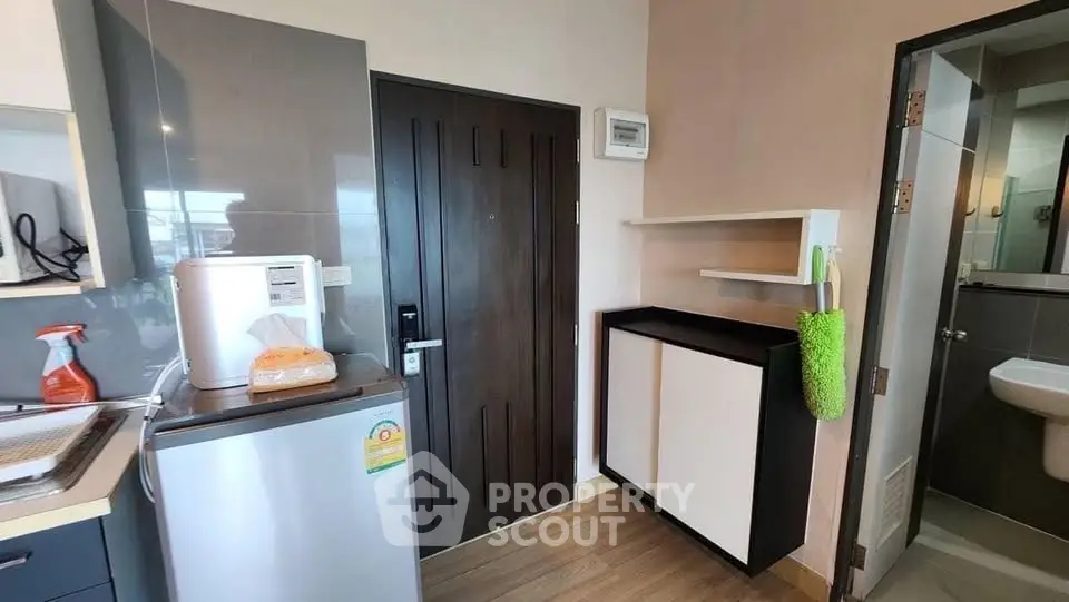 Compact kitchen area with modern appliances and storage in a cozy apartment.