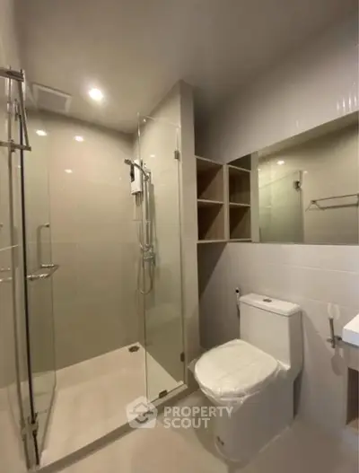 Modern bathroom with glass shower and sleek fixtures in a contemporary home.