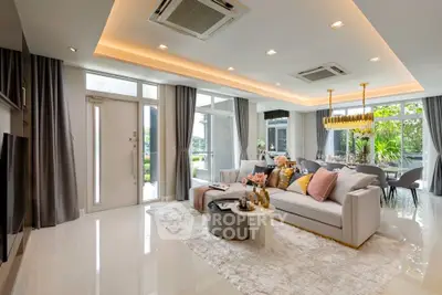 Luxurious open-plan living room with elegant decor and large windows offering garden views.