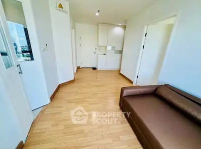 Spacious living room with wooden flooring and modern sofa in a bright apartment.