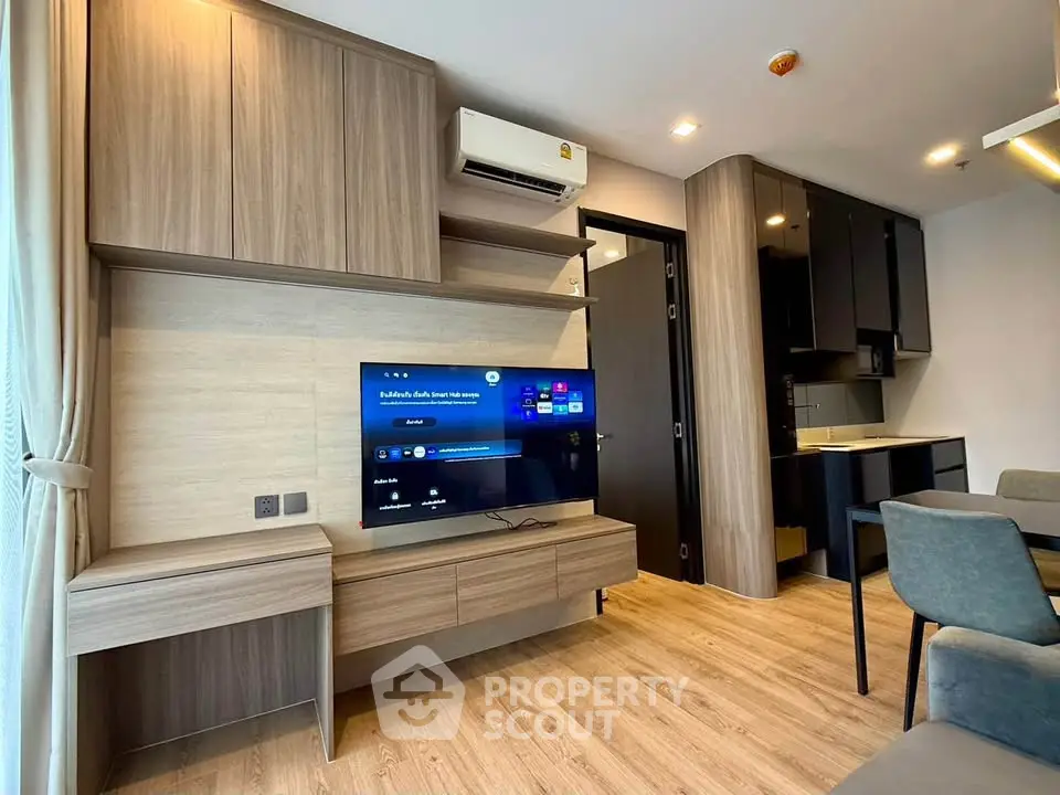 Modern living room with stylish wooden furniture and open kitchen layout in a contemporary apartment.