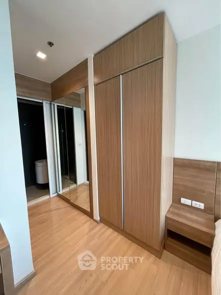 Modern bedroom with sleek wooden wardrobe and mirrored sliding doors