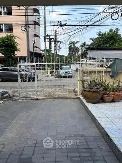 Spacious driveway with secure gated entrance and tiled flooring, ideal for urban living.