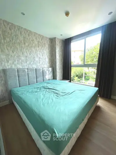 Spacious bedroom with large window and modern decor