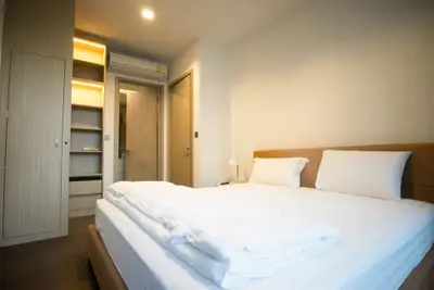 Modern bedroom with cozy lighting and built-in storage in a stylish apartment.