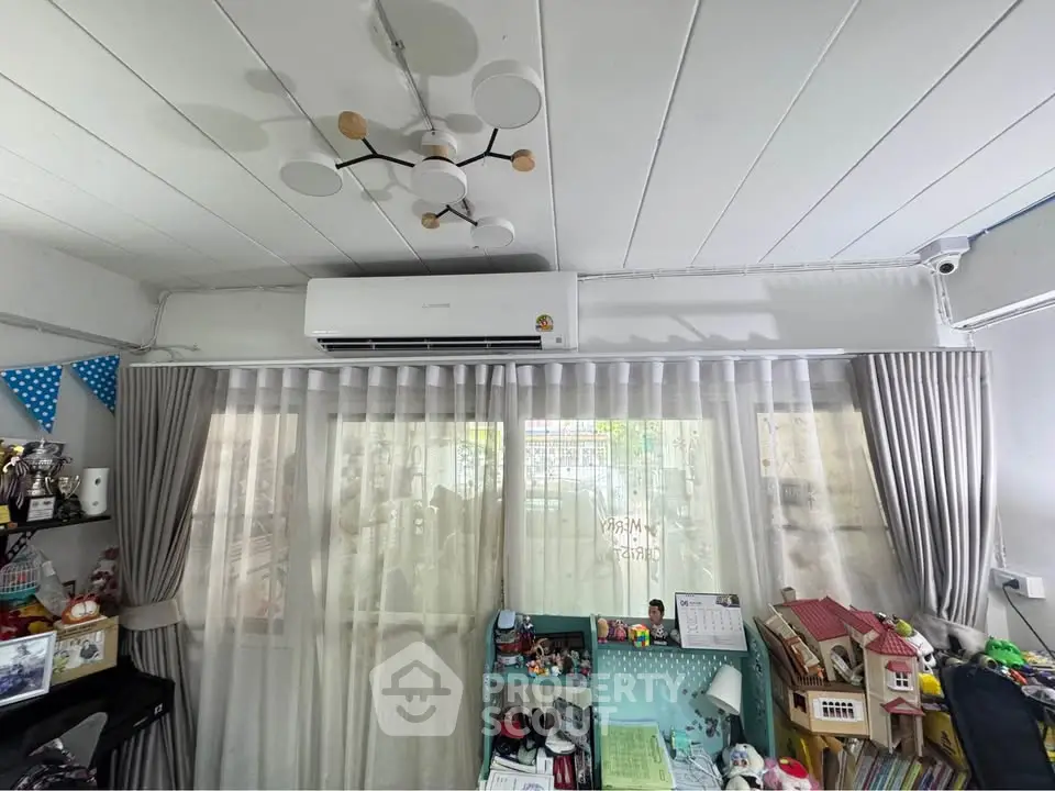 Charming living room with modern air conditioning and elegant curtains, perfect for cozy family gatherings.