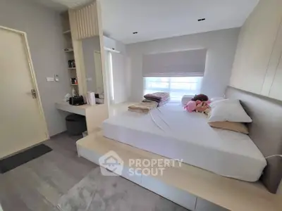 Modern bedroom with minimalist design and cozy ambiance, featuring a comfortable bed and ample natural light.