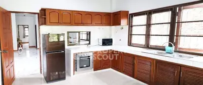 Spacious kitchen with wooden cabinets, modern appliances, and large windows for natural light.
