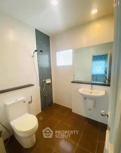 Modern bathroom with sleek design, featuring a shower, toilet, and sink with a large mirror.