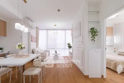 Modern open-plan living room with dining area and bedroom, featuring elegant decor and natural light.
