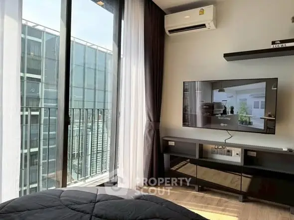 Modern bedroom with city view and sleek TV setup, perfect for urban living.