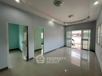 Spacious living room with tiled flooring and ample natural light, featuring modern ceiling lights.