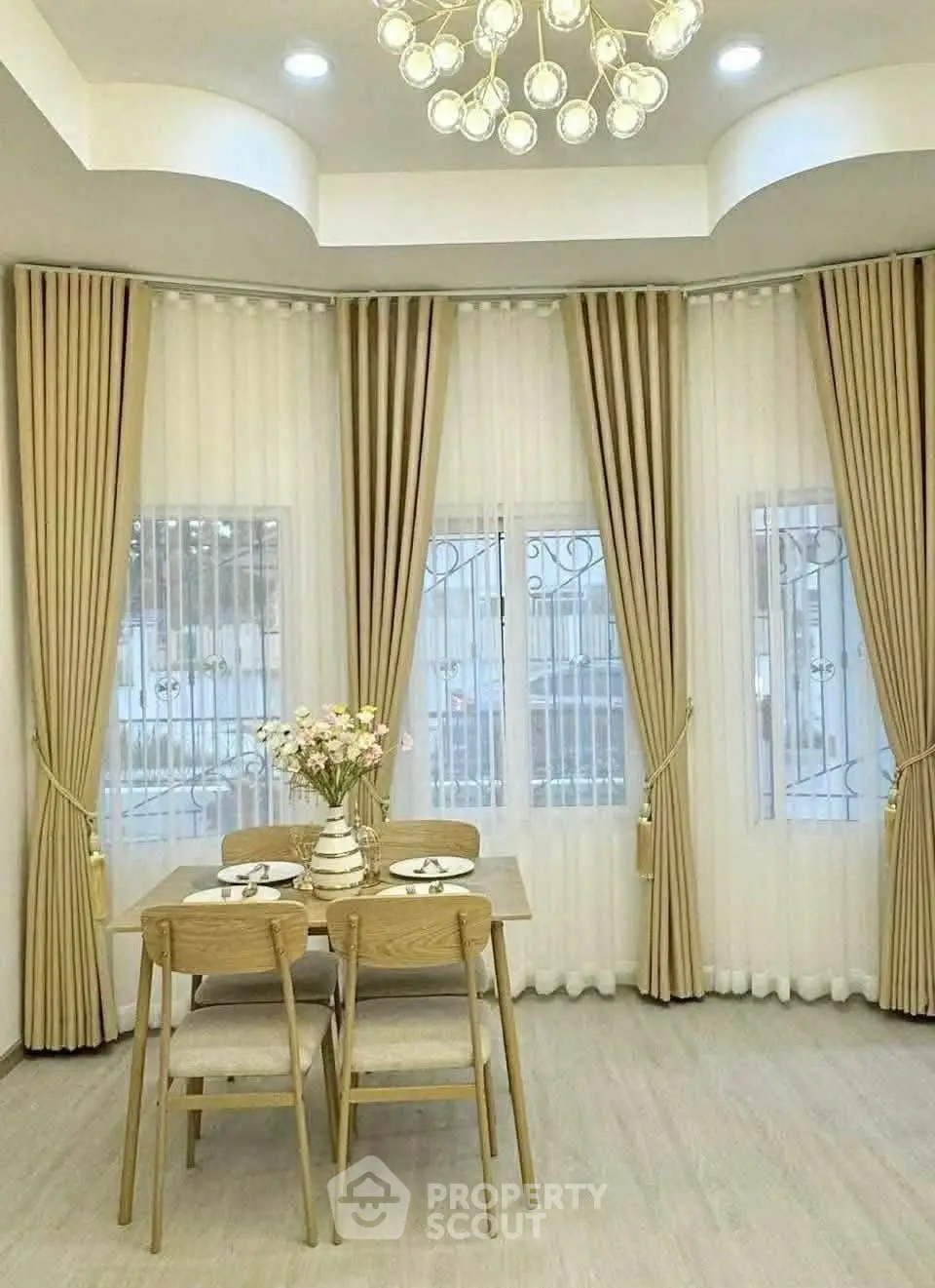 Elegant dining area with modern chandelier and floor-to-ceiling windows.
