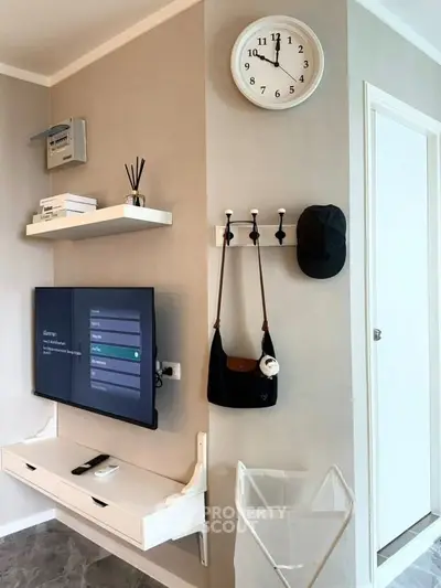 Modern living room with wall-mounted TV, stylish shelves, and chic decor accents.