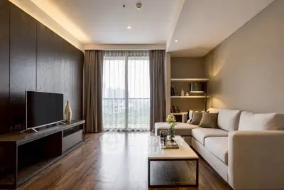 Elegant living room with modern decor, large window, and cozy seating area.