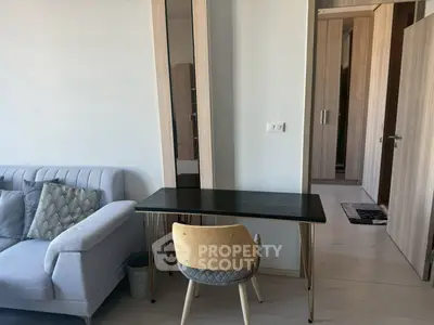 Modern living room with stylish desk and chair, adjacent to cozy sofa and hallway view.