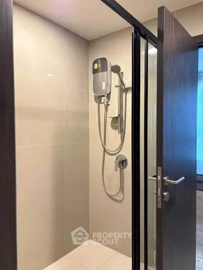 Modern bathroom with sleek shower design and glass door in contemporary apartment.