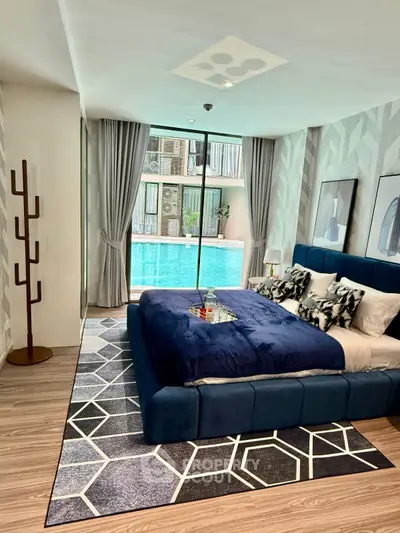 Luxurious bedroom with pool view, modern decor, and stylish furnishings in a high-end property.