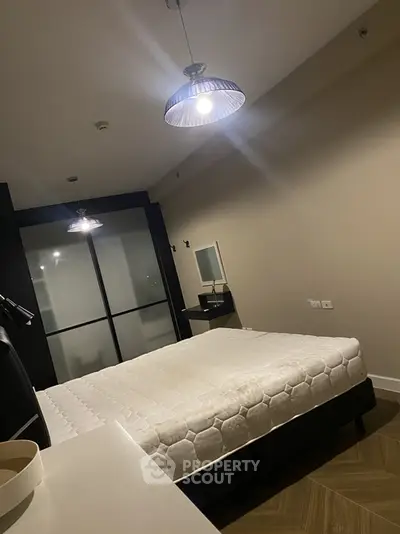 Modern bedroom with stylish lighting and minimalist decor in a contemporary apartment.