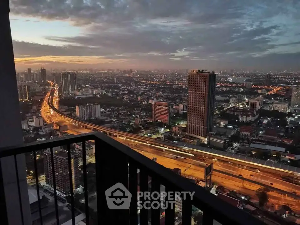 Stunning cityscape view from a high-rise balcony at dusk, showcasing vibrant city lights and skyline.