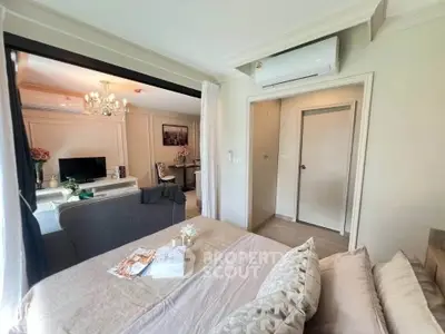 Elegant bedroom with open layout to living area, featuring modern decor and air conditioning.